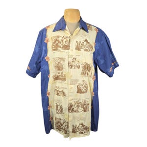 May include: A short-sleeved button-down shirt with a cream-colored center panel featuring sepia-toned illustrations and text. The sleeves and collar are a solid blue with a floral and palm tree pattern. Pink flowers are placed along the edges.