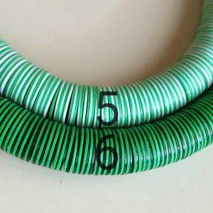 May include: Two green and white striped hoses with black accents. The hoses are coiled and labeled with the numbers 5 and 6.