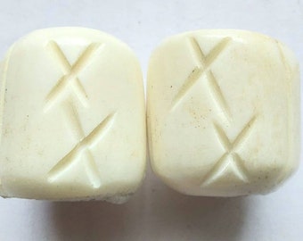 May include: Two white ceramic knobs with a diamond pattern carved into the surface.