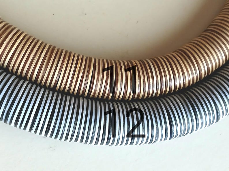 May include: Two woven hoops, one with brown and white stripes and the other with black and white stripes. The hoops are labeled with the numbers "11" and "12".