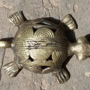 May include: A gold-colored metal turtle figurine with intricate details on its shell. The turtle is a popular symbol of good luck and longevity.