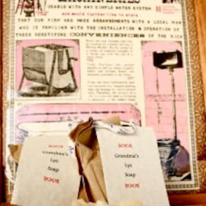 May include: Two brown paper bags with white twine tied around them. The bags are labeled "Grandma's lye soap". A bar of white soap is sitting on top of the bags. The bags are in front of a vintage advertisement for "Farrel & Ritter Indoor Machineries".