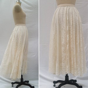 May include: A white lace skirt with a delicate floral pattern. The skirt is full and flowing, and it has a waistband.