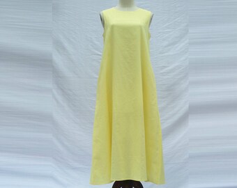 Peut inclure: Une robe maxi sans manches de couleur jaune pâle avec un col rond. La robe est faite d'un tissu léger et a une silhouette fluide.