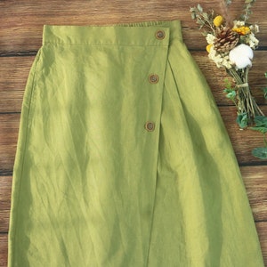 May include: A green linen skirt with a wrap-around design and wooden buttons.