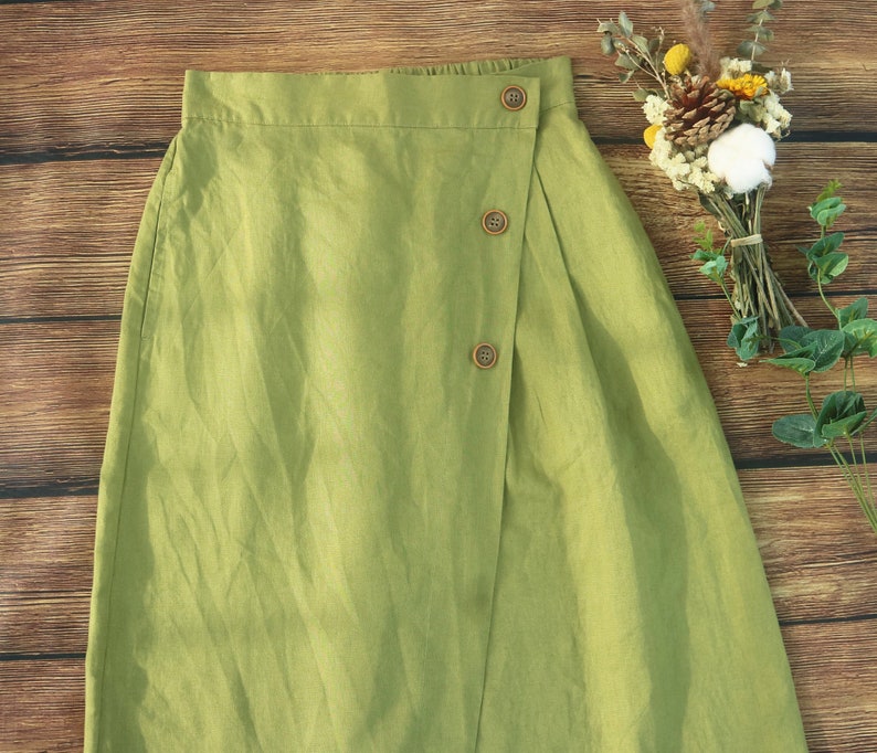 May include: A green linen skirt with a wrap-around design and wooden buttons.
