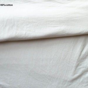 May include: Close-up of a white cotton fabric folded in half. The text "Lining: 100% cotton" is visible in the top left corner of the image.