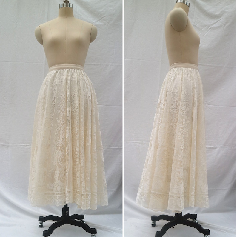 May include: A white lace skirt with a gathered waist and a full, flowing silhouette. The skirt is made of delicate lace with a floral pattern.