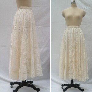 May include: A white lace skirt with a full, flowing silhouette. The skirt is made of delicate lace with a floral pattern. It is shown on a white background.