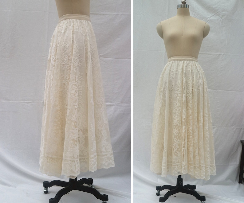 May include: A white lace skirt with a full, flowing silhouette. The skirt is made of delicate lace with a floral pattern. It is shown on a white background.