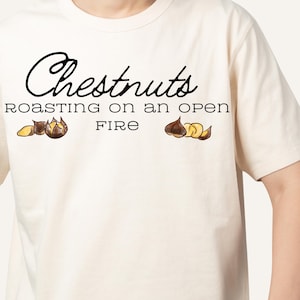 May include: A white t-shirt with the text "Chestnuts roasting on an open fire" printed in black. The text is surrounded by two illustrations of chestnuts.