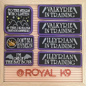 May include: A collection of eight purple and black embroidered patches with white text. The patches feature quotes from the TV show "The Good Place" and the text "@ROYAL K9".