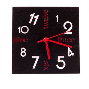 Slate clock with red and white numbers and red hands.