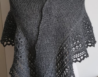 May include: A grey knitted shawl with a delicate lace border. The shawl is draped over a white mannequin.