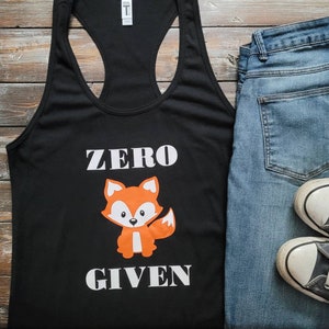 May include: Black tank top with a white graphic that says "ZERO GIVEN" and a cartoon orange fox.