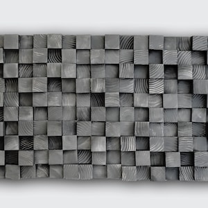 May include: A rectangular wall art piece composed of numerous gray wooden blocks. The blocks are arranged in a grid pattern, creating a textured surface. The wood grain is visible on the blocks, adding visual interest. The piece is likely for home decor.