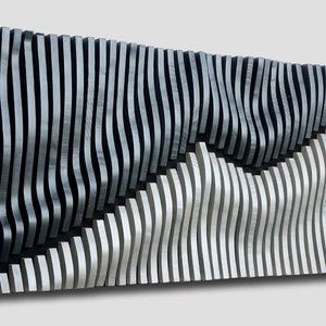 May include: Abstract wall art featuring a layered design of vertical wooden slats. The artwork is divided into two sections, one in light gray and the other in black, creating a contrast. The slats have a wavy pattern.
