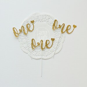 12 EINS für Cupcakes. Papier mit Goldglitter. Geburtstag. Dekorative Elemente. Cupcake-Topper.