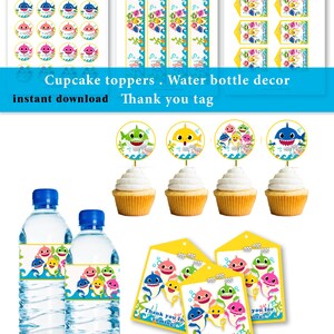 Pode incluir: Um conjunto de artigos para festas com tema de tubarão. Inclui toppers para cupcakes, rótulos para garrafas de água e etiquetas de agradecimento. Os designs apresentam tubarões de desenhos animados coloridos. O texto "Cupcake toppers. Water bottle decor instant download Thank you tag" é visível.