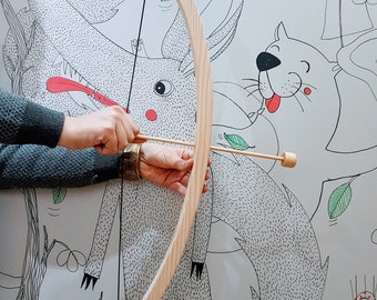 May include: A wooden bow and arrow set with a natural wood finish. The bow is curved and the arrow is straight with a wooden tip.