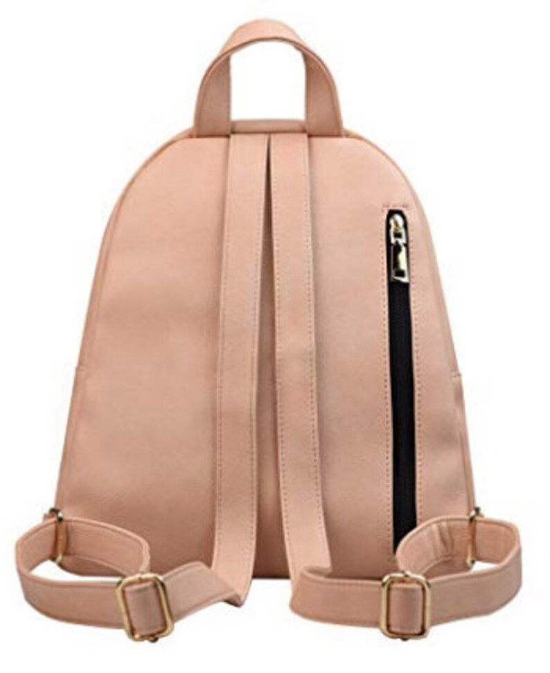 May include: A blush pink faux leather backpack with adjustable straps and a zippered pocket on the side. The backpack has gold hardware.