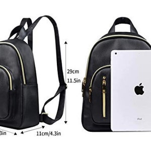 May include: Black faux leather backpack with gold accents and zippers. The backpack has a main compartment, a front pocket, and two side pockets. It measures 10.3 inches wide, 11.5 inches tall, and 4.3 inches deep.