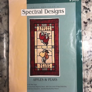 Può includere: Un modello di cucito vintage per una trapunta in stile vetrata con mele e pere. Il modello è intitolato "Apples & Pears" e include istruzioni per la cucitura a macchina con l'aspetto della cucitura a mano. Il modello è di Cathy Robiscoe's Spectral Designs e il numero è #906.