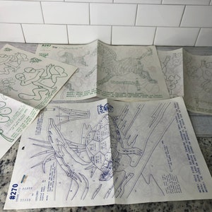 May include: A set of eight vintage paint-by-number patterns featuring various animals, including a frog, zebra, turtle, and cow. The patterns are printed on white paper with blue lines and numbers. The patterns are numbered #267 and #270.