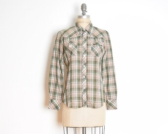 Puede incluir: Una camisa de cuadros con mangas largas y cuello abotonado. La camisa es verde y blanca con un sutil tono rosado. La camisa se muestra en un maniquí.
