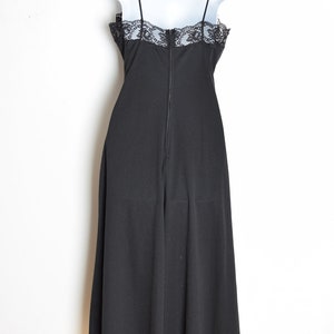 Puede incluir: Un vestido negro maxi con un borde de encaje en el escote. El vestido tiene una cremallera en la espalda.