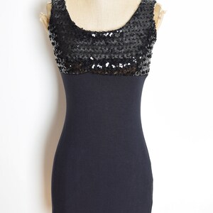 May include: A black sleeveless dress with a sequined bodice and a fitted skirt.