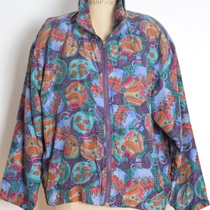 May include: A purple, blue, green, orange, and brown patterned jacket with a zipper closure. The jacket is on a mannequin.