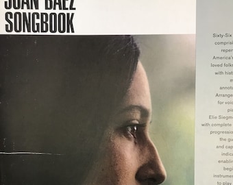 May include: The cover of "The Joan Baez Songbook" features a profile of Joan Baez. The book includes sixty-six songs, arrangements for voice and piano, and chord progressions. Illustrations are in color by Eric Von Schmidt. Published by Ryerson Music Publishers, Inc.