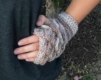 May include: A pair of crocheted fingerless gloves in a beige and white color scheme. The gloves have a textured, scaly pattern.