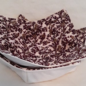 May include: A white and burgundy floral patterned fabric bowl with a white lining. The bowl is folded and ready to be used.
