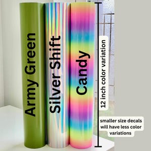 K&ouml;nnte beinhalten: Drei zylindrische Vinylrollen, die aufrecht stehen. Die erste ist in unifarbenem Armeegr&uuml;n, die zweite in reflektierendem Silver Shift und die dritte zeigt einen vertikalen Regenbogen-Farbverlauf. Ein Ma&szlig; von 12 Zoll ist angegeben.