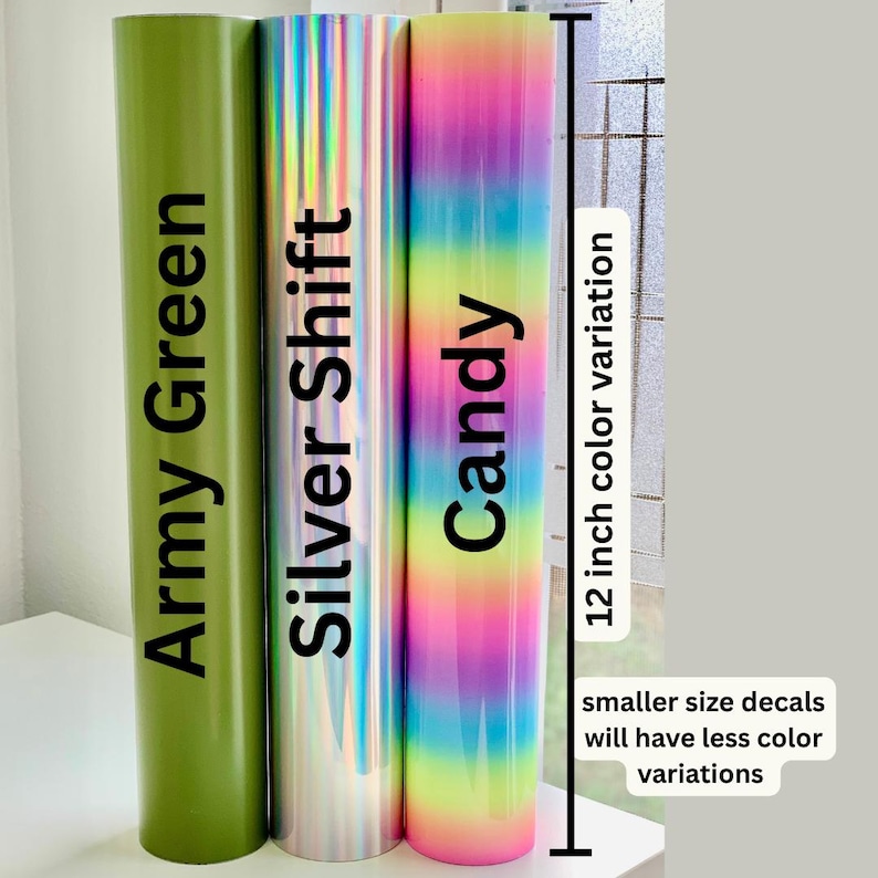 K&ouml;nnte beinhalten: Drei zylindrische Vinylrollen, die aufrecht stehen. Die erste ist in unifarbenem Armeegr&uuml;n, die zweite in reflektierendem Silver Shift und die dritte zeigt einen vertikalen Regenbogen-Farbverlauf. Ein Ma&szlig; von 12 Zoll ist angegeben.