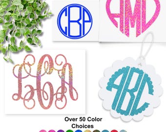 May include: Four custom monogram decals featuring various styles and colors. One blue circular monogram, one pink glitter heart monogram, one multi-colored glitter script monogram, and one teal glitter scalloped monogram. Text reads Over 50 Color Choices.