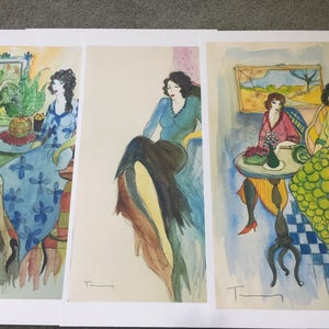 Könnte beinhalten: Drei Aquarelle von Frauen in verschiedenen Posen. Das erste Bild zeigt eine Frau in einem blauen Kleid mit Blumenmustern, die auf einem Stuhl sitzt. Das zweite Bild zeigt eine Frau in einem blauen Oberteil und einem schwarzen Rock, die auf einem Stuhl sitzt. Das dritte Bild zeigt zwei Frauen, die an einem Tisch mit einer Blumenvase sitzen. Die Bilder sind alle vom Künstler signiert.