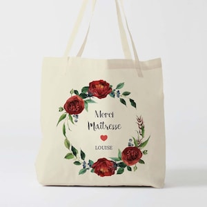May include: A white canvas tote bag with red floral wreath and the text "Merci Maitresse LOUISE" with a red heart.