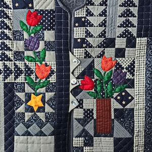 Könnte beinhalten: Eine gesteppte Weste mit Patchwork-Design. Sie zeigt rote und orangefarbene Tulpen, lila Blumen und einen gelben Stern. Die Farbpalette umfasst Marine-, Weiß- und Grautöne. Das Design beinhaltet florale und geometrische Muster.