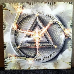 May include: A metallic, geometric design with a triangular shape in the centre. The triangle is surrounded by a circular pattern with a repeating design. The image is in shades of gold, silver, and white.