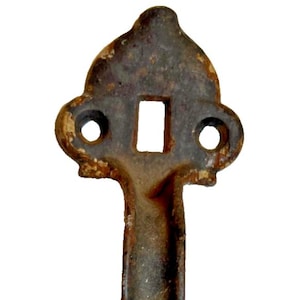以下が含まれることがあります： 暗く風化した仕上げの、素朴でアンティークなスタイルの金属製ドアハンドル。 ハンドルは長方形の開口部と上部に2つの円形の穴があり、長く垂直なグリップが付いています。 下部には装飾的で華やかなデザインがあります。