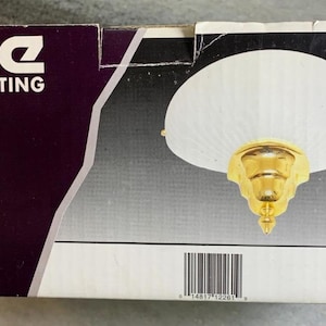 Pode incluir: Uma arandela de parede de vidro branco com acabamento em latão. A arandela é etiquetada como "Royce Lighting" e "Leaf and Pleat Glass Wall Sconce RW 1111 PB".