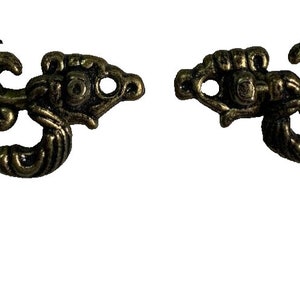 Può includere: Due tiretti per cassetti in metallo dorato decorati con un motivo floreale.