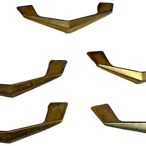 Op de afbeelding: Vijf vintage messing lade grepen met een V-vormig ontwerp. Elke greep heeft een rechthoekige handgreep en een centraal, schuin gedeelte. Het messing heeft een warme, verouderde patina, wat suggereert dat het antieke of vintage hardware is.