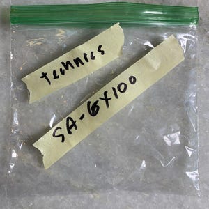 May include: A clear plastic bag with two yellow sticky notes. One note says "techniques" and the other says "SA-6X100".