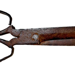 May include: A pair of antique scissors with large, rounded finger holes and a long, pointed blade. The scissors have a rusty brown color, indicating age and use. The blades are slightly open, suggesting they are ready for cutting.