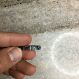 Peut inclure: Une clé vierge en métal argenté avec une extrémité carrée.