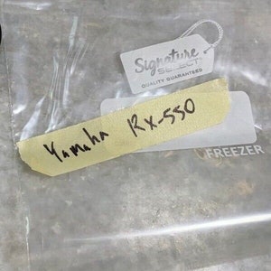 Puede incluir: Un primer plano de una etiqueta amarilla con escritura negra que dice "Yamaha RX-550" y una etiqueta blanca con escritura negra que dice "Signature Select Quality Guaranteed".